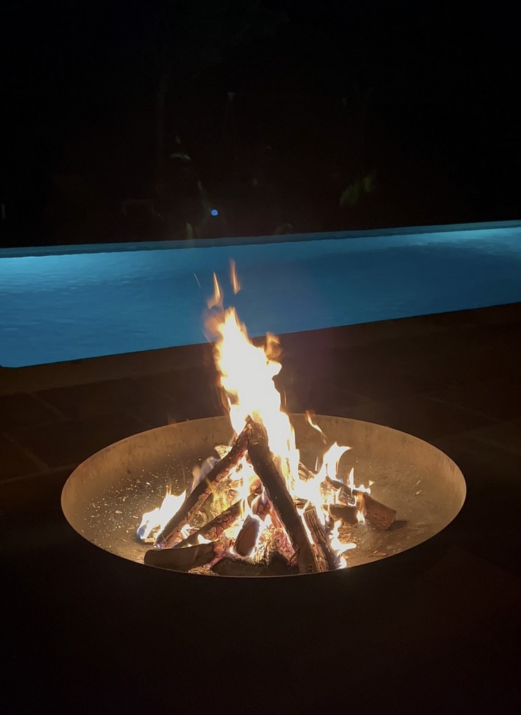 Hoguera junto a la piscina durante la noche